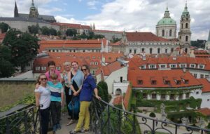 group of people smiling in front of view of red rooftops