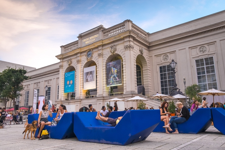 Visitors relax on blue public art sculpture seats in Vienna's MuseumQuartier